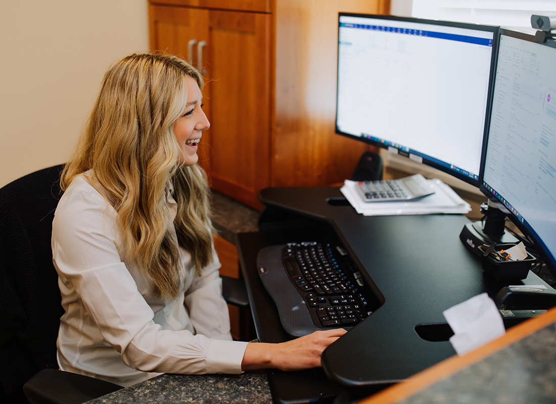 Read Our Reviews - AIC Insurance Services Team Member Using a Computer at the Office